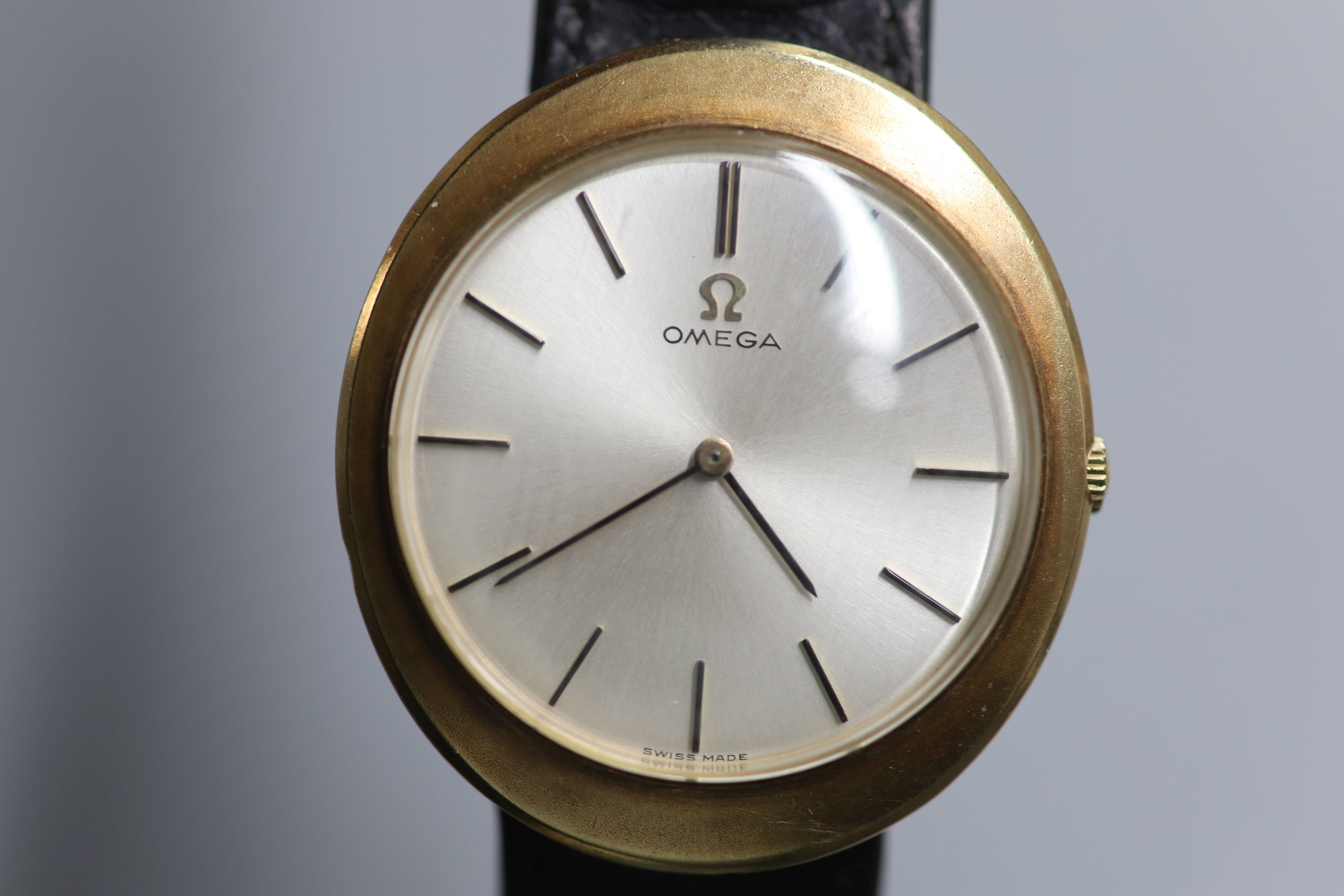 A gentlemans 9ct gold Omega manual wind dress wrist watch, on associated damaged leather strap,